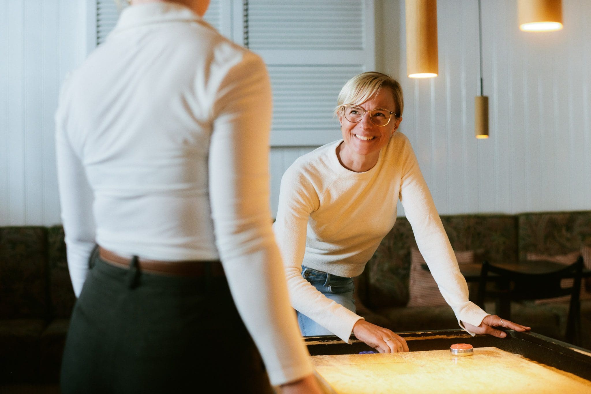 kvinde griner til sin kvinde mens hun spiller shuffle